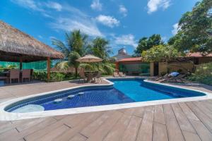 a swimming pool in a backyard with a wooden deck at Casa de praia completa in Paulista