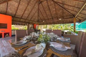 a dining room with a table with glasses and chairs at Casa de praia completa in Paulista