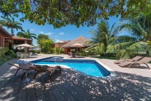 a swimming pool with a wooden deck next to a house at Casa de praia completa in Paulista