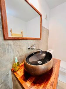 y baño con lavabo de madera y espejo. en L'Ylang Ylang Auberge d'AMBATOLOAKA, en Ambatoloaka