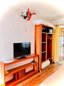sala de estar con TV de pantalla plana sobre una mesa en L'Ylang Ylang Auberge d'AMBATOLOAKA, en Ambatoloaka