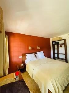ein Hotelzimmer mit einem Bett und einem Tisch in der Unterkunft L'Ylang Ylang Auberge d'AMBATOLOAKA in Ambatoloaka