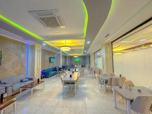 un ristorante con tavoli, divani e sedie di Hotel Chanel Plaza a Erbil