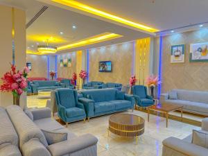 a large waiting room with blue couches and flowers at Hotel Chanel Plaza in Erbil
