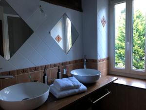 un bagno con due lavandini e un grande specchio di La Forge d'Espy a Illier-et-Laramade Altre 37 foto
