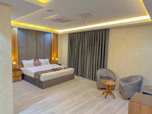 una camera d'albergo con letto e sedia di Hotel Chanel Plaza a Erbil