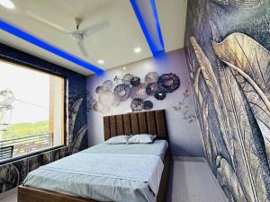 1 dormitorio con 1 cama con una pintura en la pared en HOTEL THE PUNJAB KING -- MODERN DHABA, BAR, SUITE ROOMS -- Special for Families, Couples, Corporate, Group Travelers, en Phagwāra