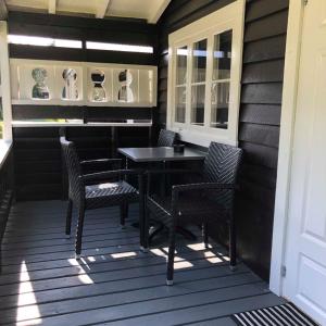 a porch with chairs and a table and a piano at Sølvgarden Camping in Rysstad