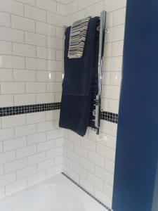 uma casa de banho com uma toalha preta pendurada numa parede em Shepherd's Rest Apartments Central Location With Parking em Tewkesbury