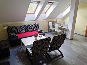 a living room with a couch and a table and chairs at Penzion Vincent in Dolní Moravice