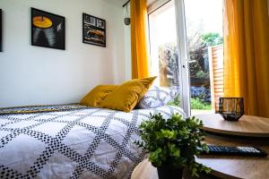 a bedroom with a bed and a table and a window at LE GABRIELE de PESSAC in Pessac