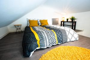 una camera da letto con un letto bianco e nero con cuscini gialli di LE GABRIELE de PESSAC a Pessac