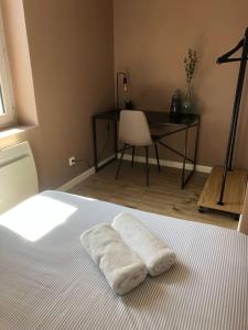 a bedroom with a bed with two white towels on it at Appartement Vignes Vienne nord in Vienne