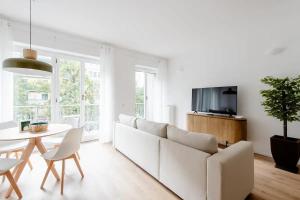 Sala de estar blanca con sofá blanco y mesa en Luxury 2 bedroom Apartament, close to San Siro, Fiera and 10 min metro to Duomo, en Milán