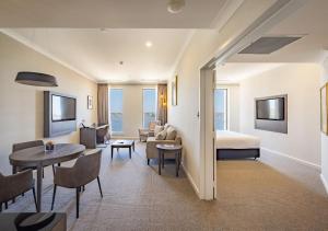 a hotel room with a bed and a living room at Duxton Hotel Perth in Perth