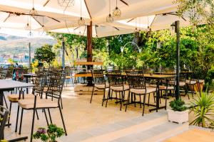 um restaurante ao ar livre com mesas, cadeiras e guarda-sóis em Heritage Hotel Pasike em Trogir