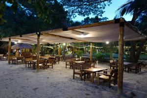 a group of tables and chairs under a canopy at The Sevenseas Resort Koh Kradan in Koh Kradan