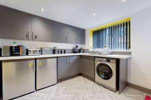 a kitchen with a washer and dryer in it at Neat Retreat Graig Pontypridd in Pontypridd