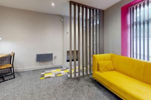 uma sala de estar com um sofá amarelo e uma televisão em Neat Retreat Graig Pontypridd em Pontypridd