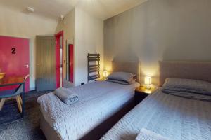 a bedroom with two beds and a desk with two lamps at Neat Retreat Graig Pontypridd in Pontypridd