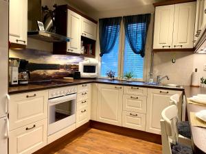 cocina con armarios blancos y fogones en Fully-equipped apt, Free parking, private backyard, en Kotka