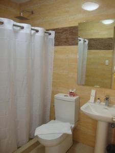 een badkamer met een wit toilet en een wastafel bij Devera Hotel in Malabañas