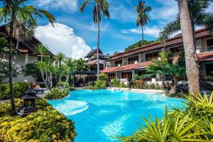 uma piscina em frente a um resort com palmeiras em Phi Phi Banyan Villa em Phi Phi Don