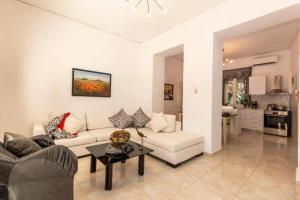 a living room with a white couch and a table at Gogo's Cosy Beach House in Rethymno