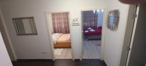 - une chambre avec un lit et un miroir dans l'établissement APARTMAN APOLON, à Doboj