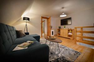 a living room with a blue couch and a tv at Karolinka Holiday Homes in Karolinka