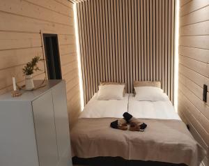 a bedroom with a bed with a teddy bear on it at Scandinavian lakeside cottage in Rovaniemi