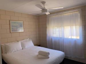 a bedroom with a white bed with a ceiling fan at Harbour View 49 Urch Street Unit 2 in Geraldton