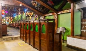 a restaurant with green walls and a row of wooden stalls at Treebo Trend Bhairavee in Pune