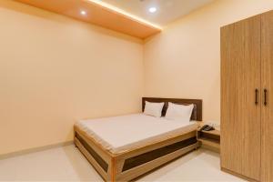 a small bedroom with a bed and a cabinet at OYO Hotel Ambika Palace in Patna