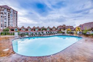 a large swimming pool with chairs and a building at Sunset Waterfront Resort #1306 in Kelowna