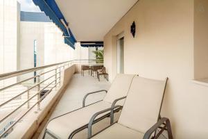 a balcony with two white chairs and a table at LUX Apt Puerto Banus-Pool-Terrace 5 min to beach in Marbella