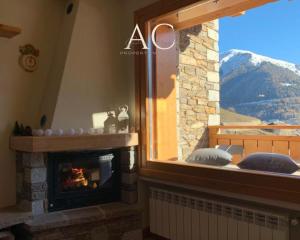 a fireplace in a room with a view of a mountain at Villa Nice View in Ponte di Legno
