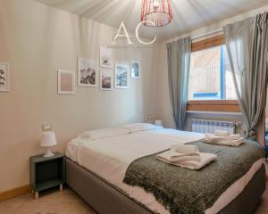 a bedroom with a bed and a window and a chandelier at Villa Nice View in Ponte di Legno