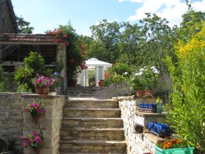 a set of stairs with potted plants and flowers at Dordogne Farmhouse in Beaulieu-sur-Dordogne