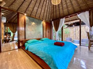 a bedroom with a large blue bed in a room at Little Tree House in Sanur +35 photos