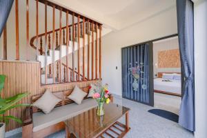 una sala de estar con escaleras y un jarrón de flores sobre una mesa en Moon River House en Hoi An