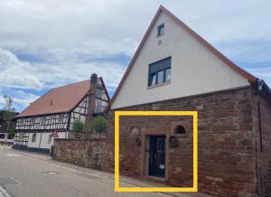 ein Haus mit einem gelben Rahmen um die Tür in der Unterkunft Sonnenhof 1737 - Ferienzimmer & Apartments in Barbelroth