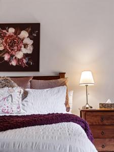 um quarto com uma cama com uma pintura de flores na parede em The Noble Grape Guesthouse em Cowaramup