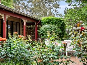 um jardim em frente a uma casa com flores em The Noble Grape Guesthouse em Cowaramup