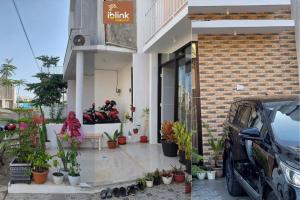 瑪琅的住宿－IbLink Homestay Family Homestay di Dau Malang，一座有植物和摩托车停放在外的建筑