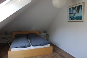 a bed with two blue pillows in a room at Ferienwohnung unter den Eichen in Schwanewede