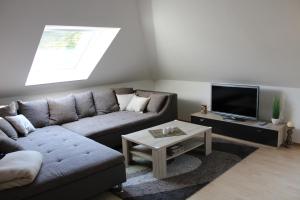 a living room with a couch and a tv at Ferienwohnung unter den Eichen in Schwanewede