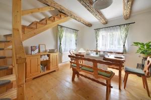 uma sala de jantar com uma mesa e uma escada de madeira em Karolinka Holiday Homes em Karolinka