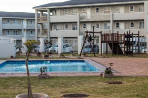 an apartment complex with a pool and a playground at False Bay Huis in Cape Town