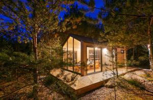 a glass house in the woods at night at Forestic Lietuva in Vilionys